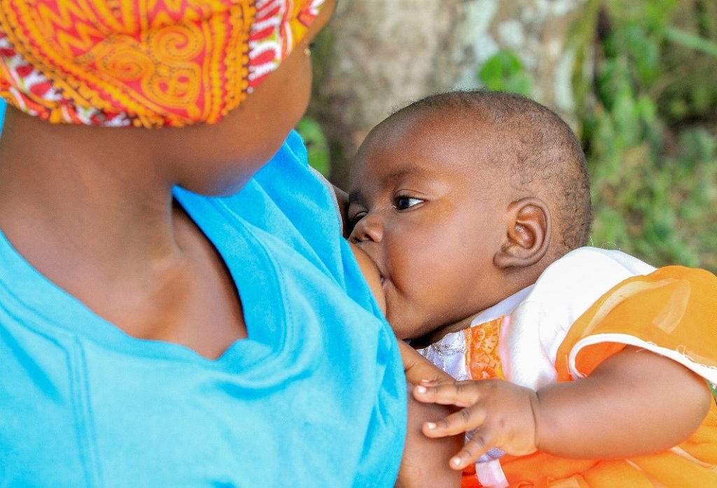 A mother-to-mother support group member breastfeeding who overcame a breastfeeding problem thanks to the group’s help.