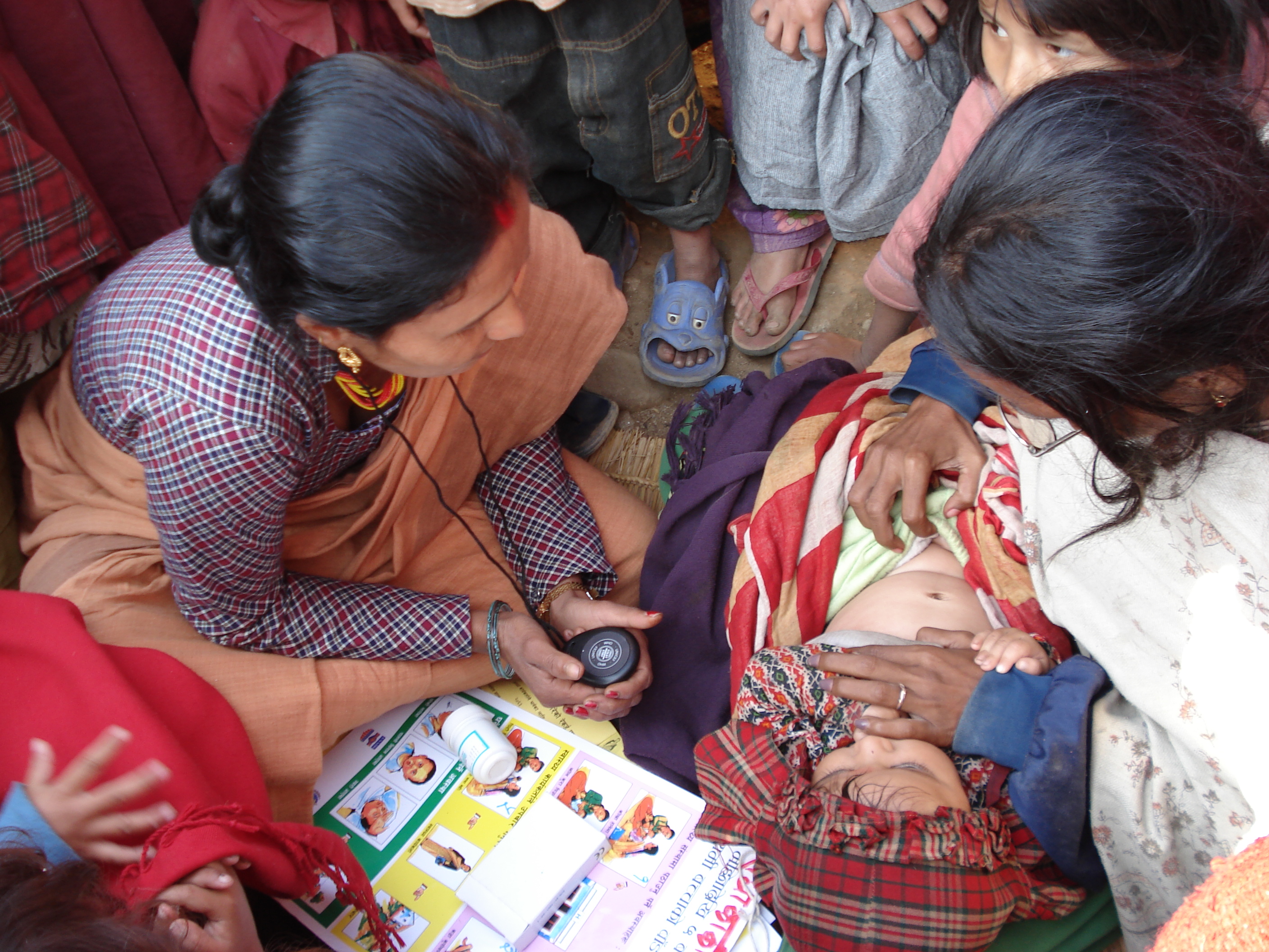 Nepali village health worker counting the respirations of a sick infant