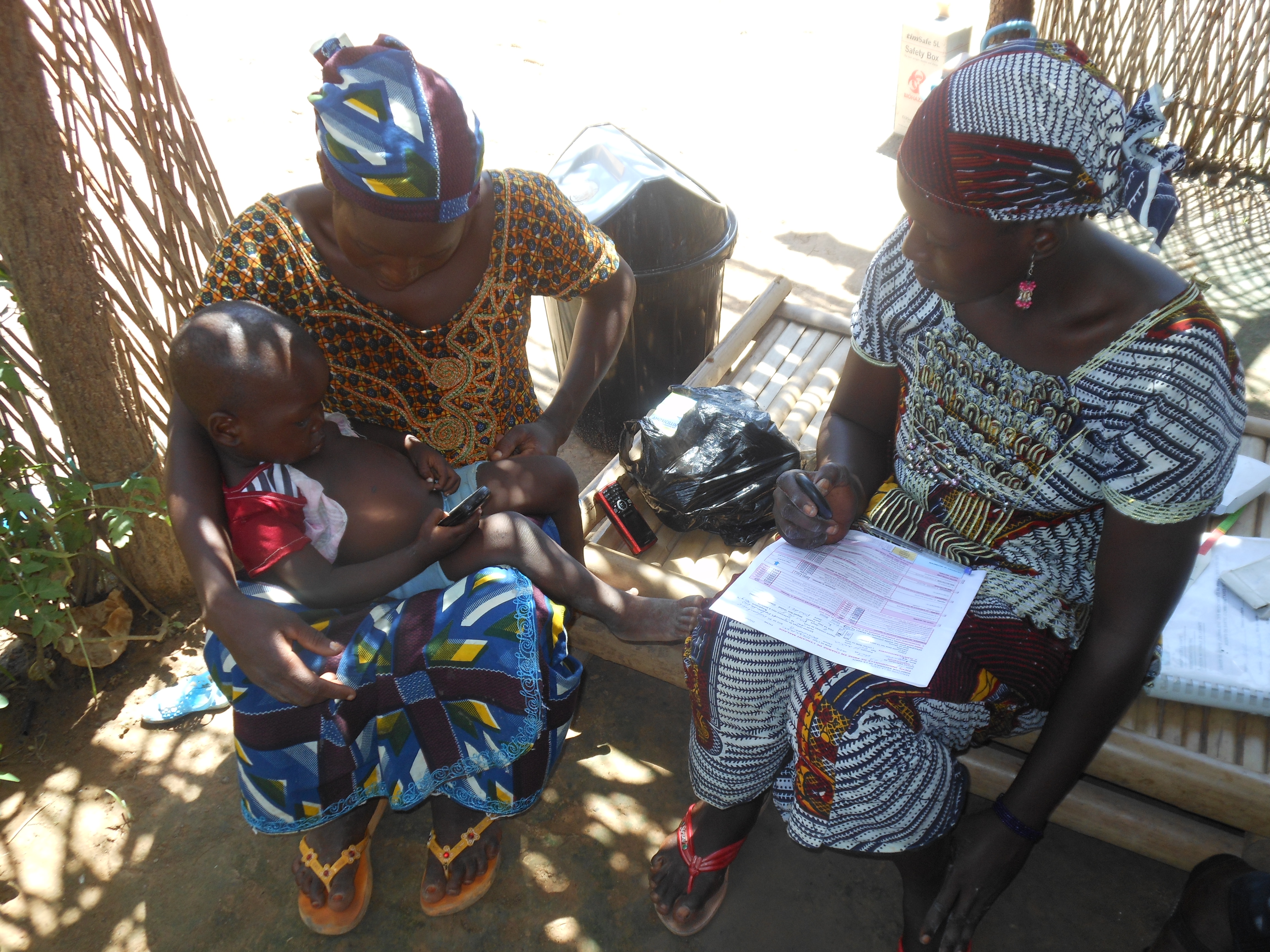 Health worker in Mali assessing the respiratory rate of a sick child