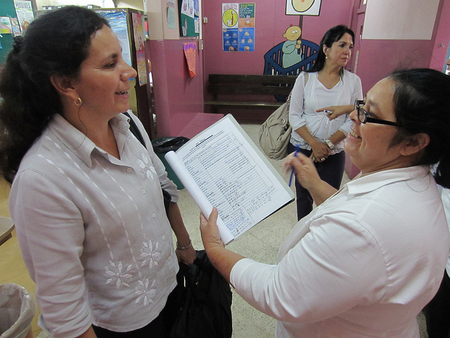 Community Interventions Advisor smiles at hospital staff as they review a chart of data