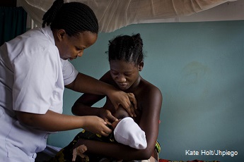 A first time mother is shown how to breast feed her new born baby by a mid wife in the Health Centre in Mlandizi, Tanzania