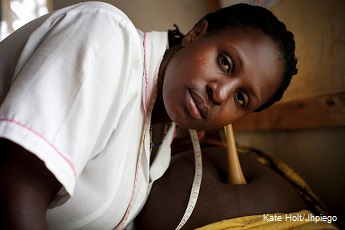 Pregnant woman being examined by a midwife in Uganda