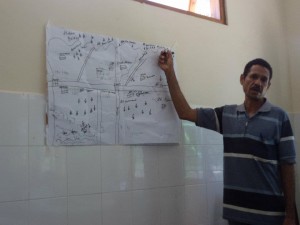 A community leader in Timor-Leste explains his community’s map during immunization micro-planning