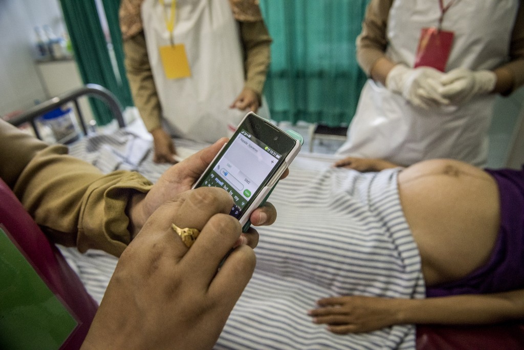 Midwife in Indonesia sends a text to the hospital, she is thinking about sending her patient there since she has been in labor for nearly a day and is three days overdue.