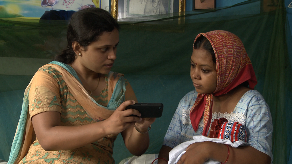 Woman with baby looking at mobile phone