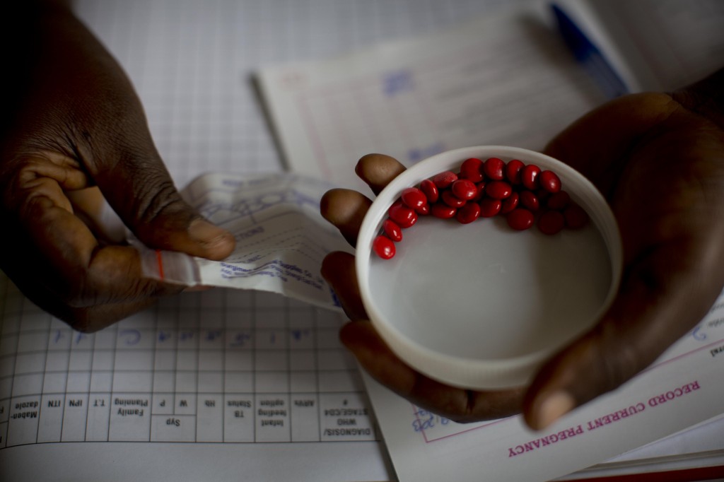 In Uganda, a midwife gives a woman in her second trimester of pregnancy iron tablets.
