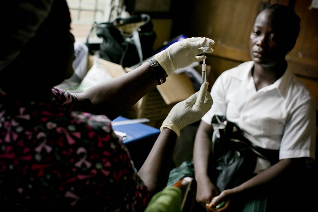 A midwife prepares a contraceptive injection for a patient at a clinic in Liberia.
