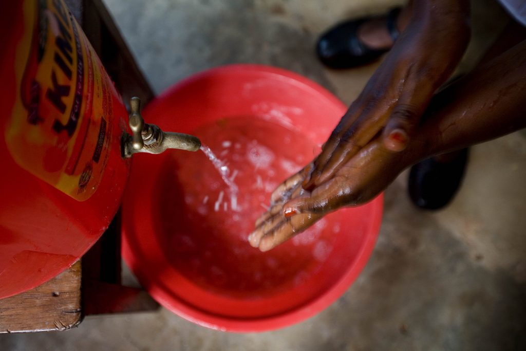 Midwife washing her hands before examining a patient