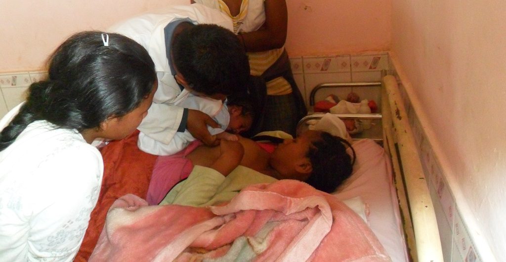 Dr. Rakotoarison helps a mother and newborn with breastfeeding.