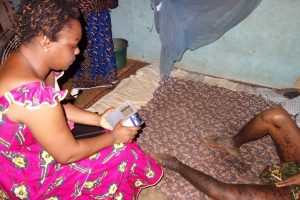 Above: Isabelle using the CommCare application during her home visit with Aka.