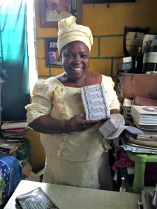 A woman in Nigeria holds boxes of chlorhexidine gel.