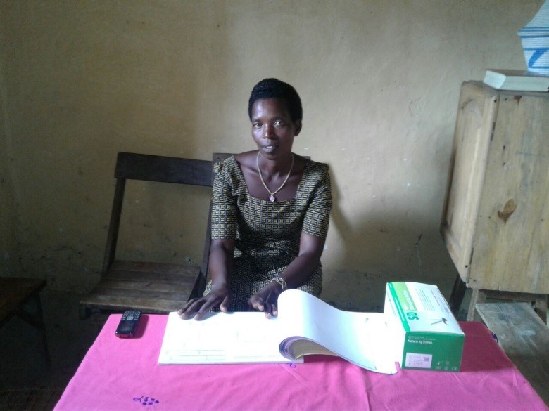 Above: Monique with the iCCM registers and malaria rapid diagnostic tests.