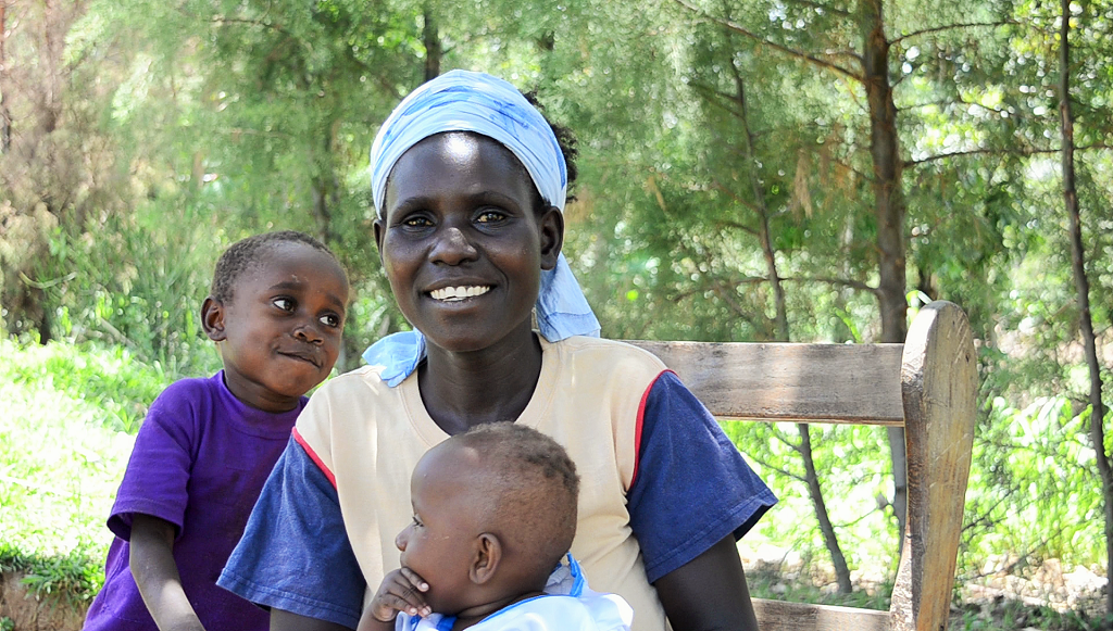 Josephine with her sixth child, Tantensia Nafula, as her older son looks on.