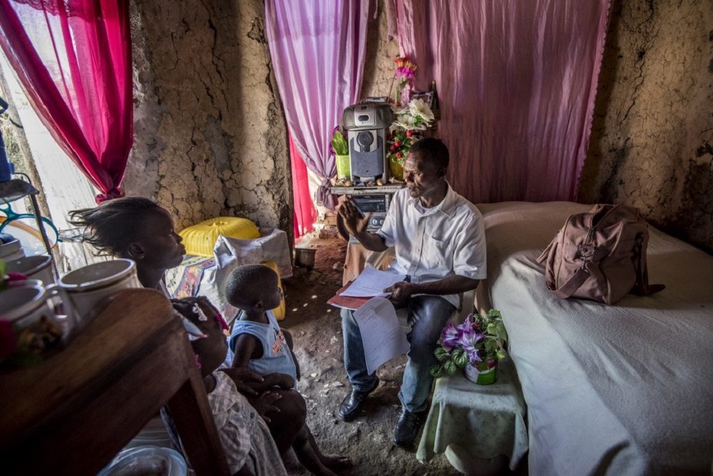 Pierre Tenor, an HIV peer educator, meets with Clothilde Brazil, a mother of six.