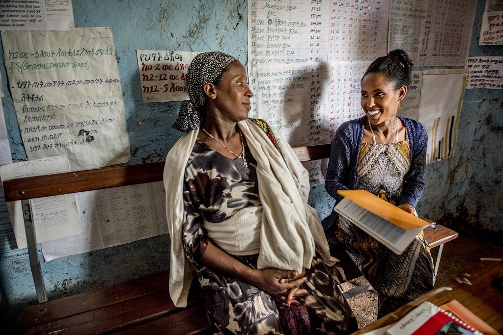 Midwife Balaynes Straw talks with Mantegbosh Wabet, 32, who is giving birth to her fourth child. She is 8 months along and her oldest is 17 years old.