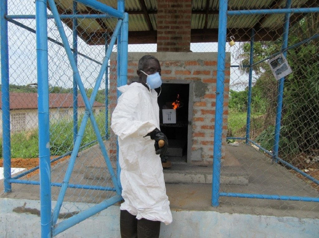 Wheagar Smith, a cleaner at Well Baby Clinic in Grand Bassa County, using the newly built incinerator