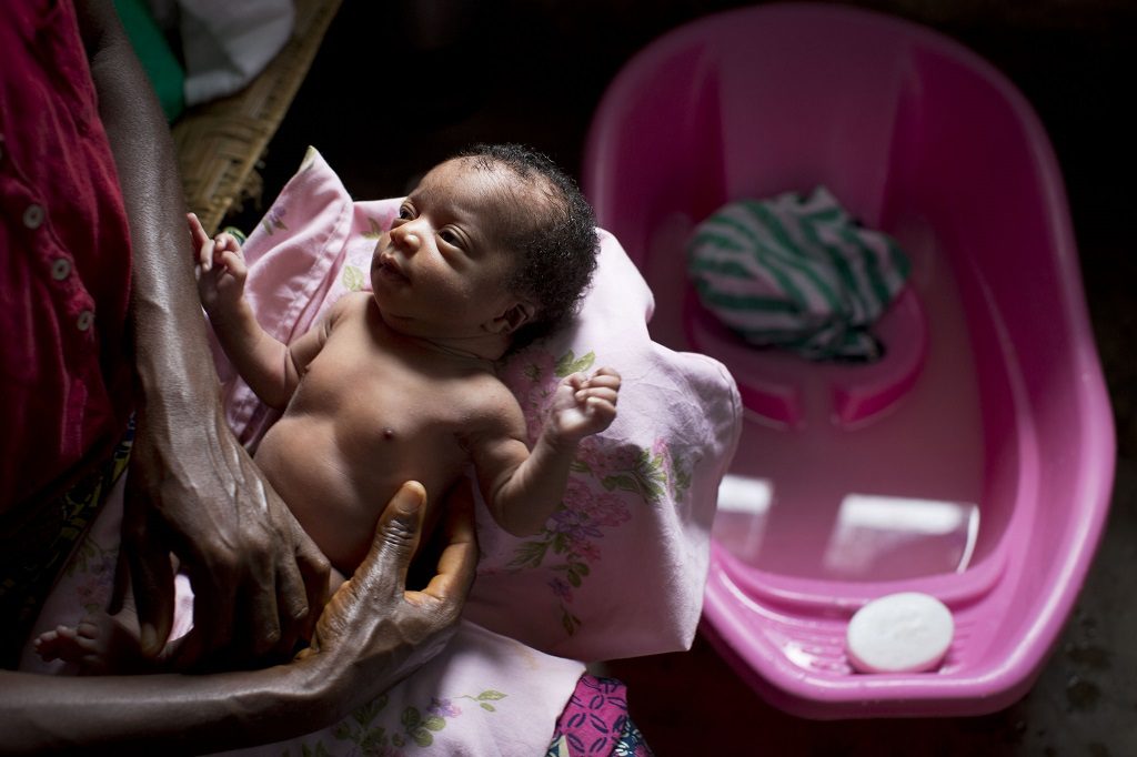 A woman cleans her newborn granddaughter at a health center in DR Congo