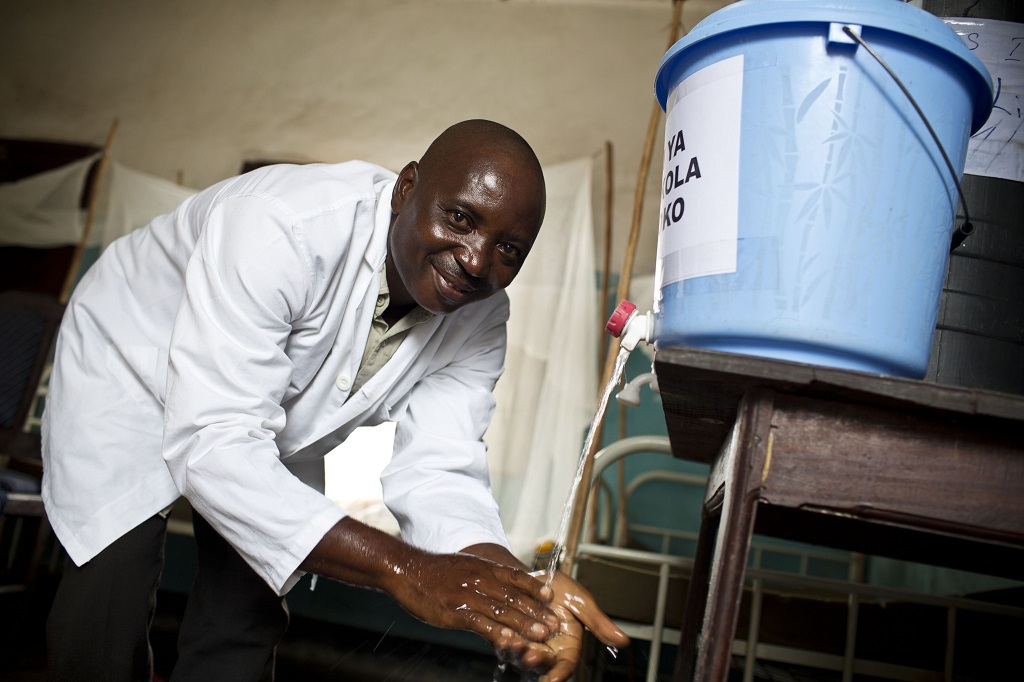 Bonny Selenga Jaques, Head Nurse at Lilanda Health Center, washes his hands at a newly installed handwashing station