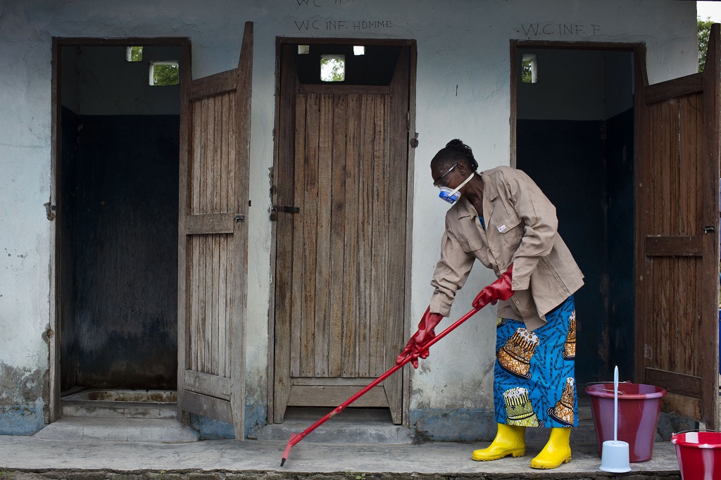 cleans the latrines at a health center in DR Congo