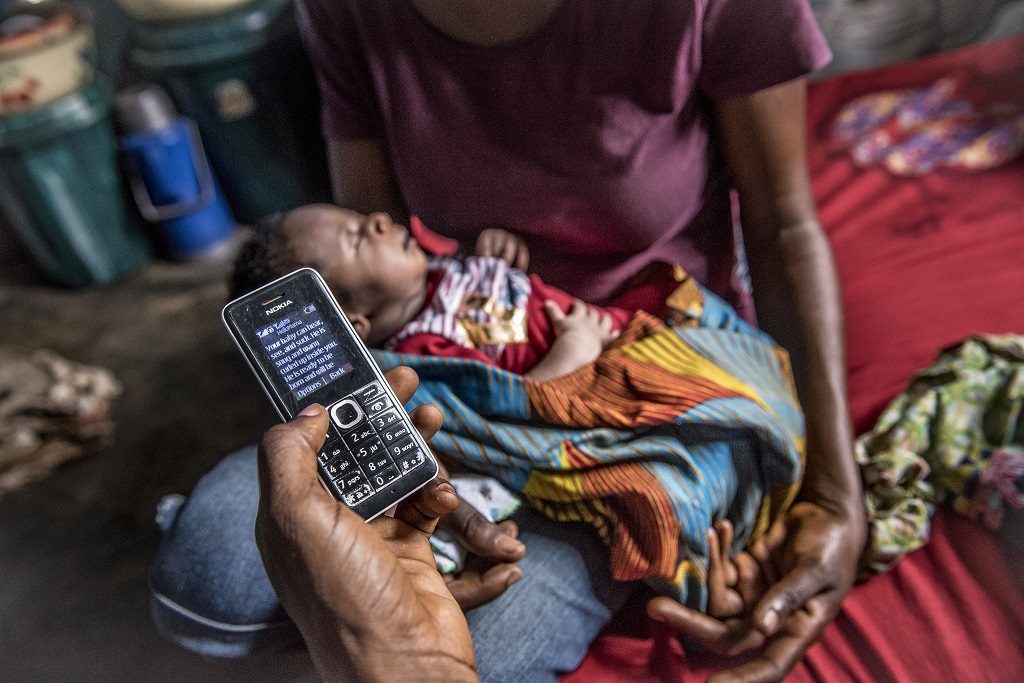 A father in Nigeria shows the health-related text messages he received while his wife was pregnant with their third child