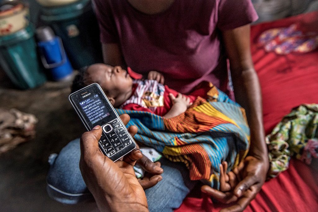 Family in Nigeria receiving health messages via mobile phone.