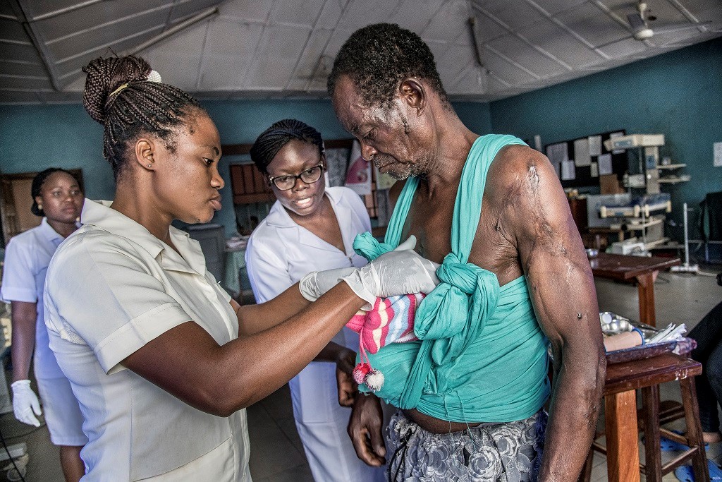 a nurse at an MCSP-supported Catholic mission hospital helps a father do skin-to-skin contact with his premature newborn