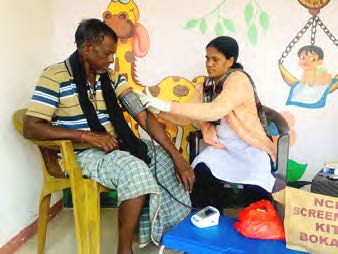 Sameena Khatoon taking a patient's blood pressure