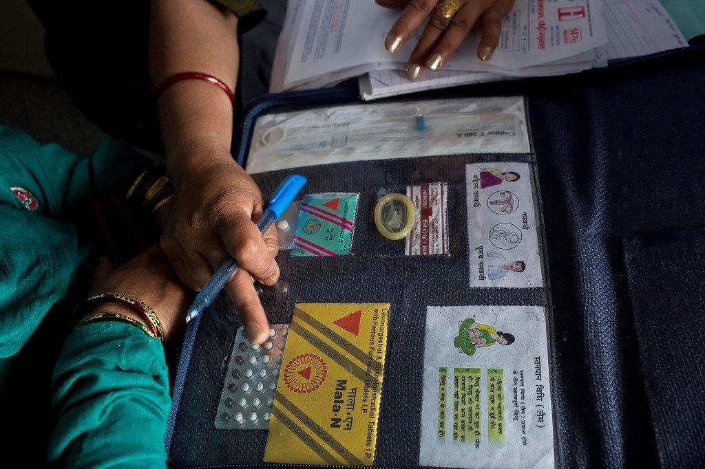 A doctor shows women available family planning methods at District Female Hospital in Pauri, India.