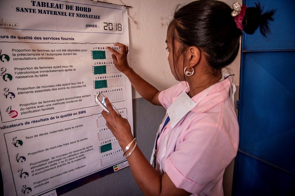 At a health clinic in Madagascar, a student nurse puts information on a dashboard