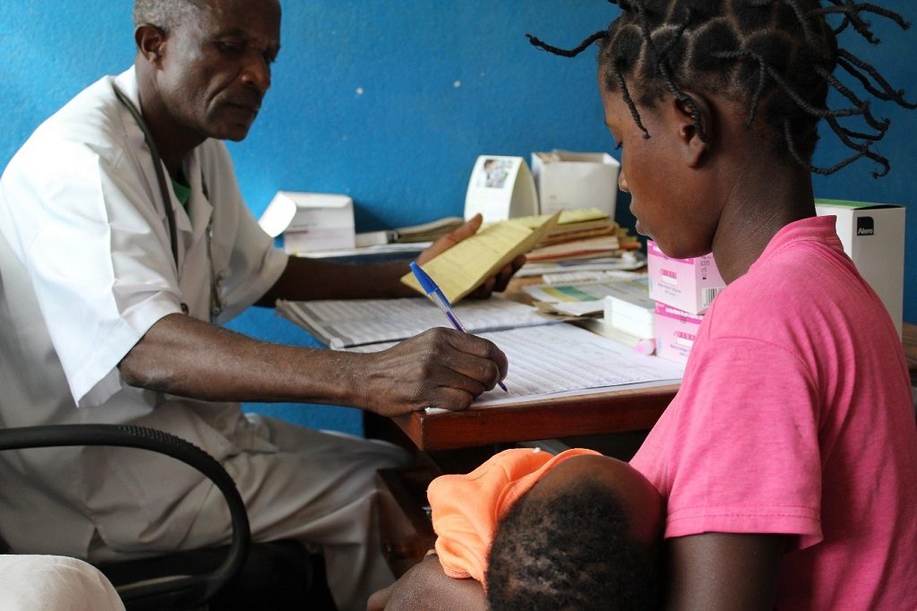 During a sick child consultation, health technician Zacarias Morruela fills in a new child health registration book.
