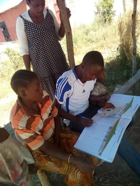 CHWs using the community register to actively trace children who are due for the MCV2 vaccine.