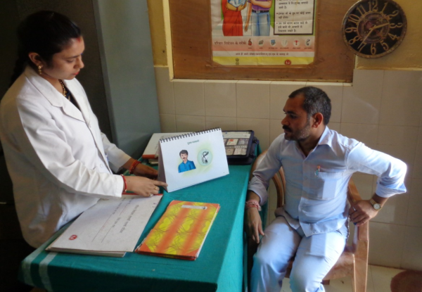 MCSP-trained counselor talks to Sahu about NSV at the community health center.
