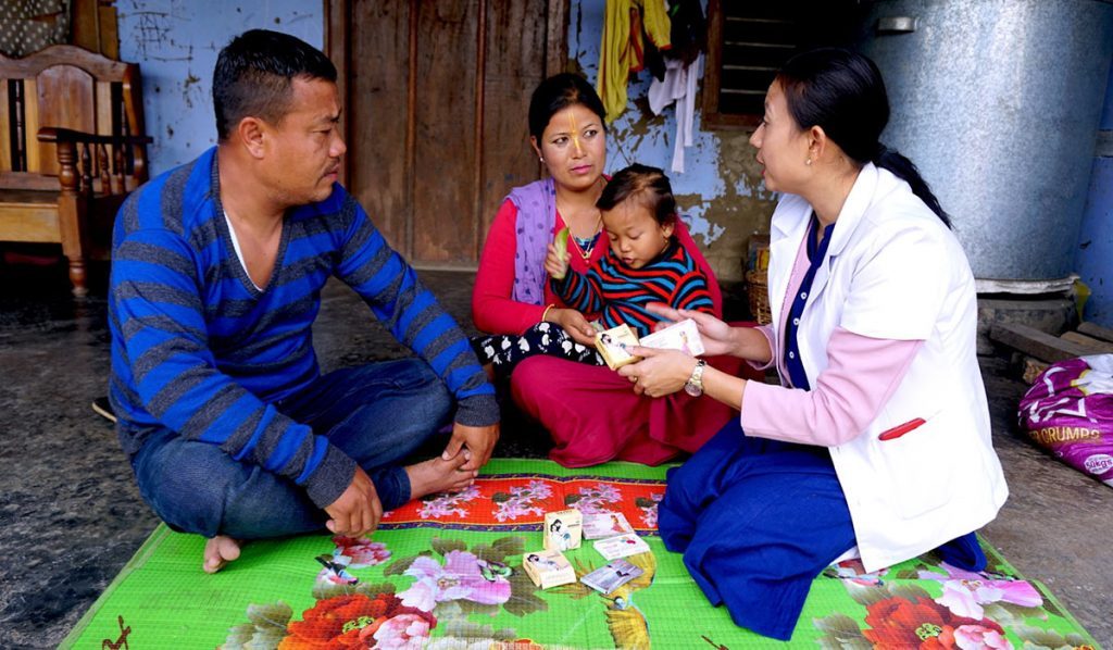 Ranita talks with parents of a young child