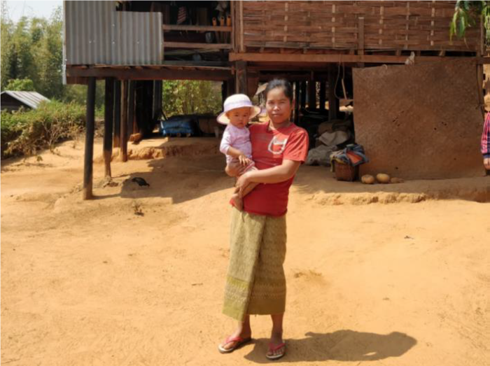 Sao and her now healthy daughter in front of their home.